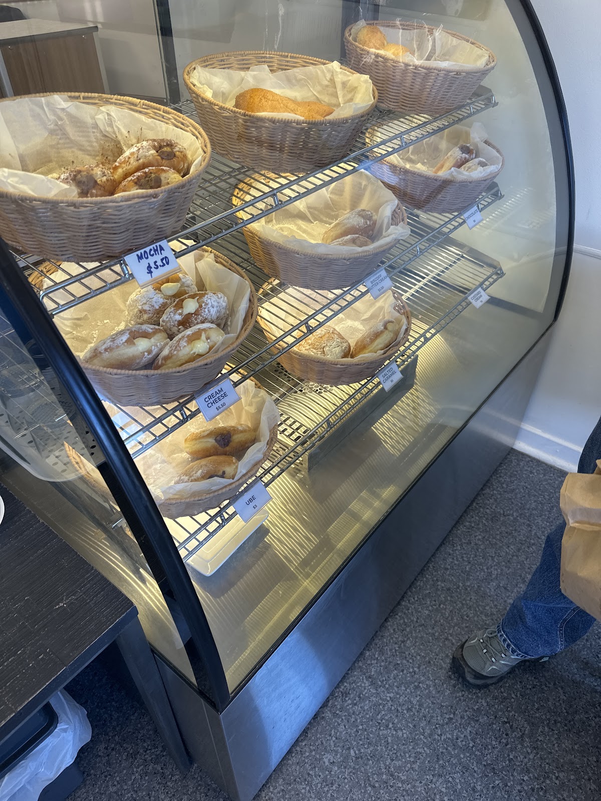 Display cabinet stacked with baskets of fresh donuts